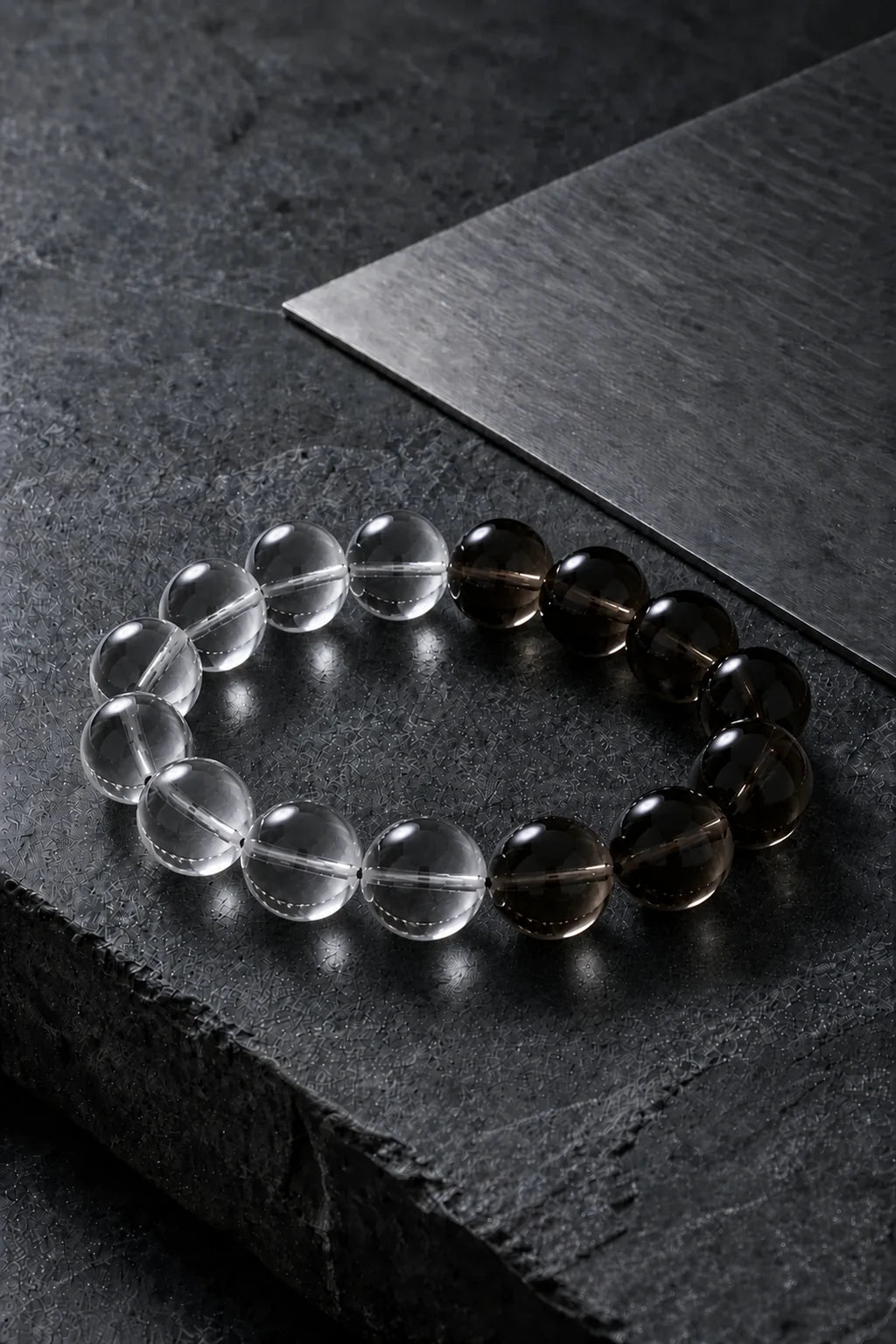 A full-size clear and smoky quartz bracelet on graphite and brushed steel